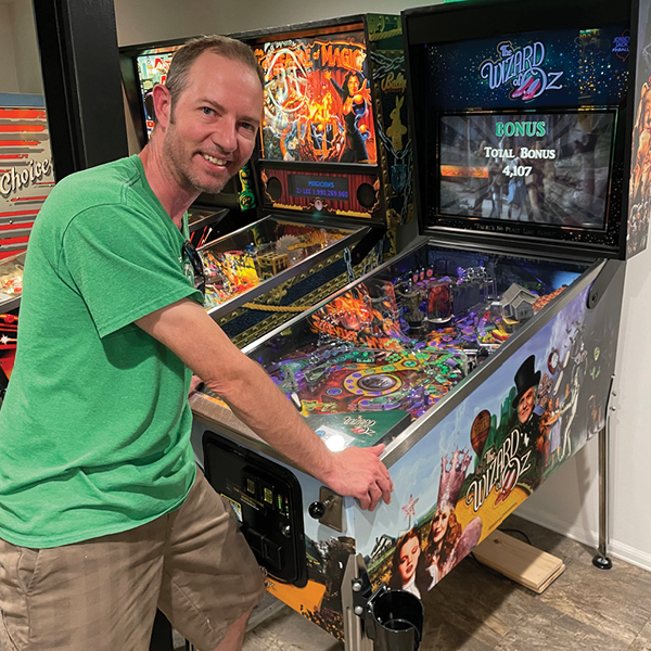 CORE employee, Jeff Anton, playing pinball in an arcade
