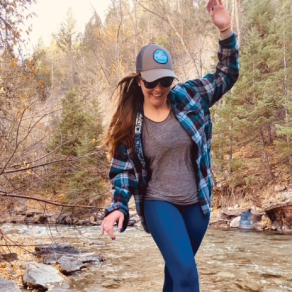 CORE employee Justine Armes, walking on rocks in a river