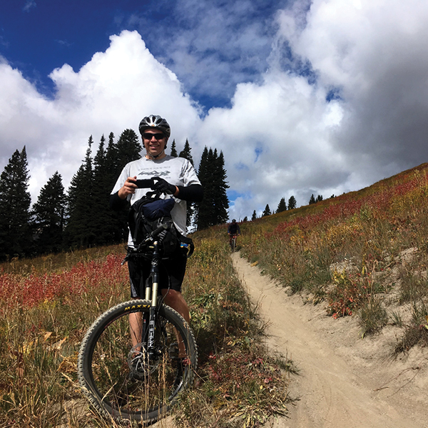 CORE employee, Rob Hansen posing with a bike on a trail