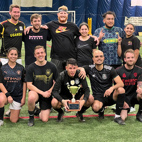 CORE employee, Justin Keller, posing with a soccer team with a trophy