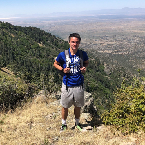 CORE employee, Dylan Godfrey, posing on a hike