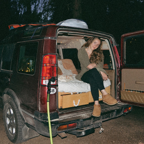 CORE employee sitting in a car camping