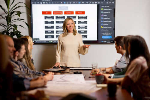 Human Resources director presenting to a team, in front of a screen